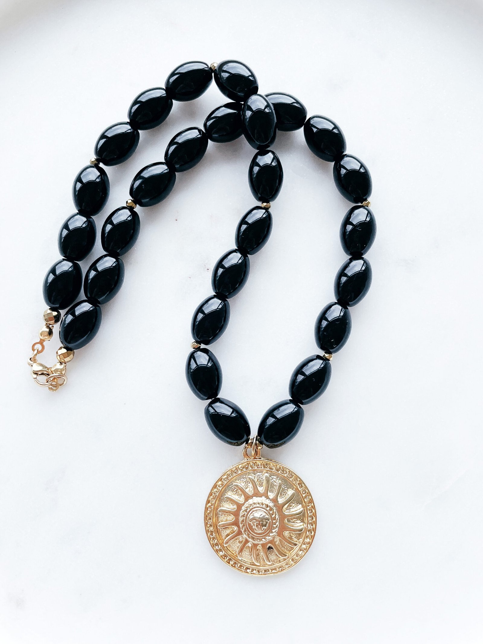 Juodas onikso vėrinys su medalionu