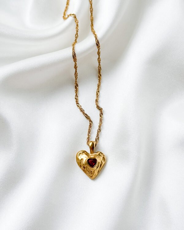 Aukso spalvos grandinėlė su širdele, dekoruota raudonu cirkoniul.