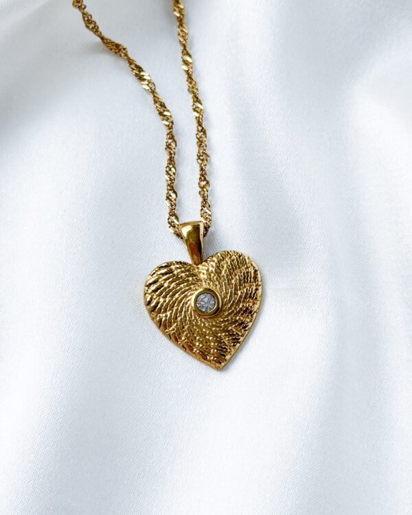 Aukso spalvos kaklo papuošalas su širdele.