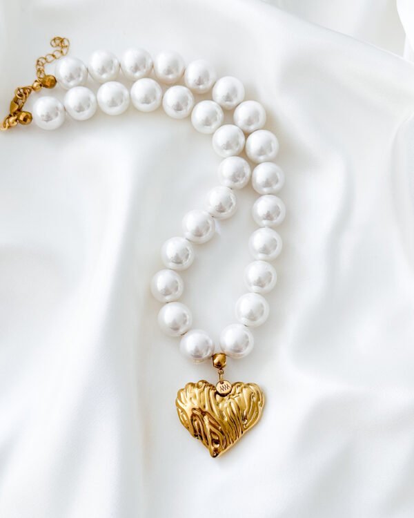 Perlų vėrinys su aukso spalvos širdelės pakabuku.