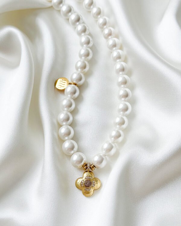 Baltos spalvos perlų vėrinys su gėlytės pakabuku.