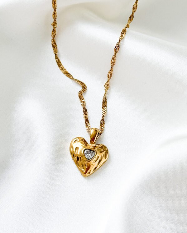 Aukso spalvos grandinėlė su širdelės pakabuku.